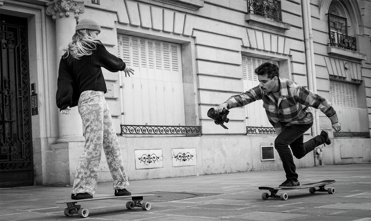 Brahim Yaqoub filmant une longboardeuse en mouvement, caméra au poing sur son propre longboard
