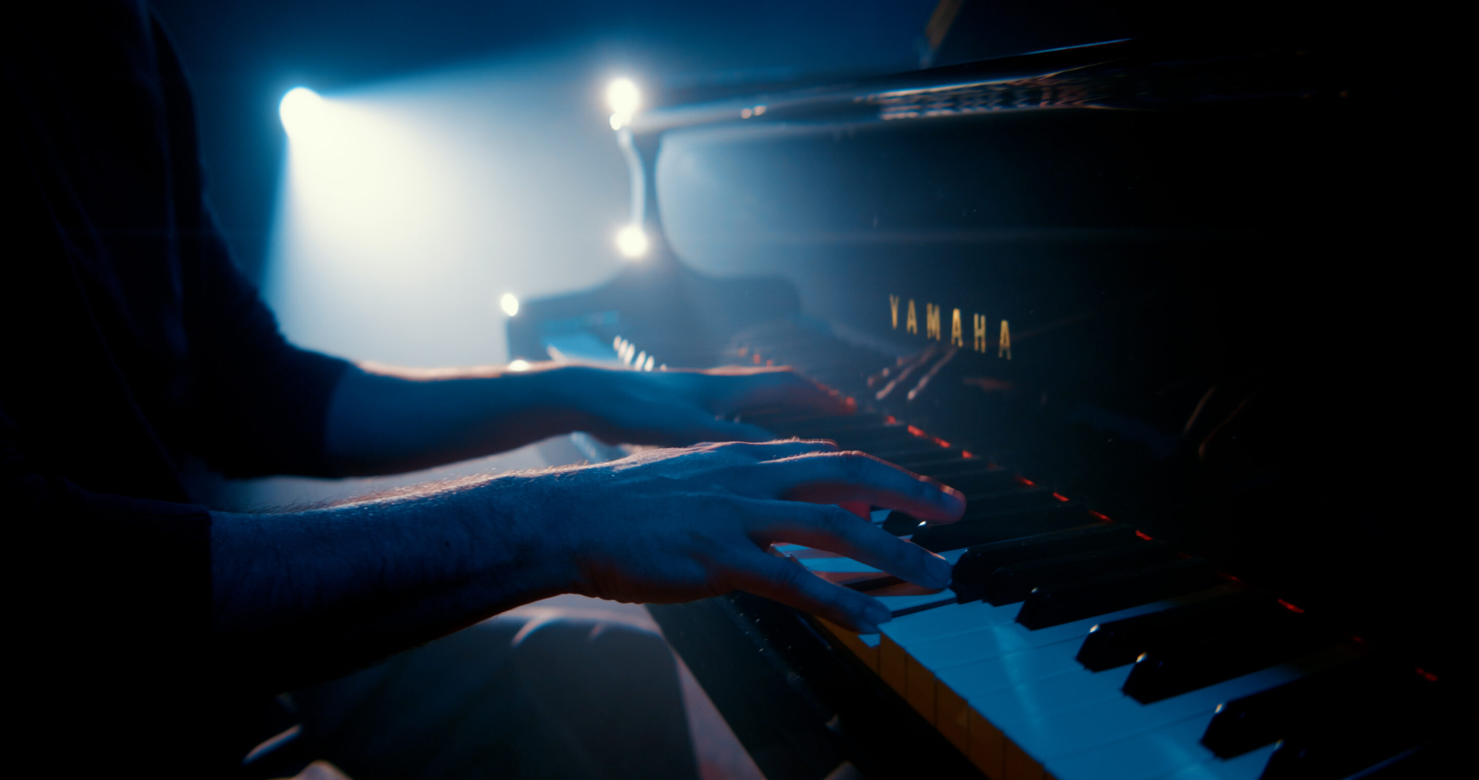 Gros plan sur les mains de Jordane Tumarinson jouant du piano Yamaha, clip Turbulence.